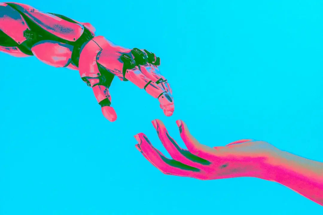 Colorful robotic hand reaching towards a human hand on a bright blue background